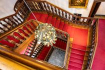 Von oben sieht die Treppe mit dem prächtige Kronleuchter so aus. Seine Entstehungszeit ist nicht genau bekannt, der Stil deutet aber auf ein Alter von ungefähr 300 Jahren hin.  • © ummeteck.de - Silke Schön