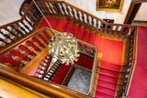 Von oben sieht die Treppe mit dem prächtige Kronleuchter so aus. Seine Entstehungszeit ist nicht genau bekannt, der Stil deutet aber auf ein Alter von ungefähr 300 Jahren hin.  • © ummeteck.de - Silke Schön