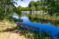 Das "Freizeitgelände für Jung und Alt" bietet mehrere Badebuchten mit Rollkies und einen kleinen Steg als Zugang zum Wasser der Agger, viele Sitzbänke, darunter eine Kinderbank.  • © ummeteck.de - Silke Schön