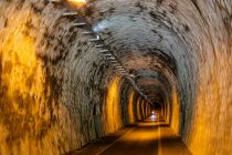 Beleuchtet und abkühlend im Sommer - Der beleuchtete Tunnel entstand an einer ehemaligen Eisenbahntrasse, 1993 wurde der Zugverkehr auf der Strecke eingstellt. Heute steht er unter Denkmalschutz.  • © ummeteck.de - Silke Schön