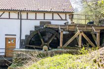 Die Mühle selbst stammt aus dem 14./15. Jahrhundert. Das Wasserrad hat einen Durchmesser von ungefähr dreieinhalb Metern. Zehn Umdrehungen schafft es in einer Minute. Die 300 Liter Wasser, die durch die Wassermühle laufen, erzeugen jährlich ungefähr 25.000 kWh Strom.  • © ummeteck.de - Silke Schön