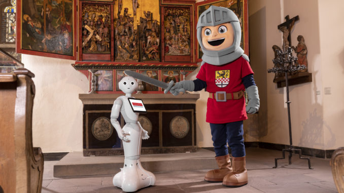 In den Museen der Burg Altena erhält Roboter-Dame Lüdia von Ritter Otto den Ritterschlag in Heimatkunde. // Foto: Michael Bahr / Märkischer Kreis